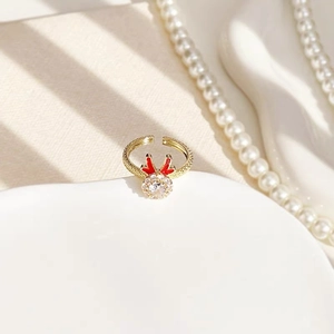 Macro shot of gold-plated Christmas ring with red enamel antlers and clear zircon stone