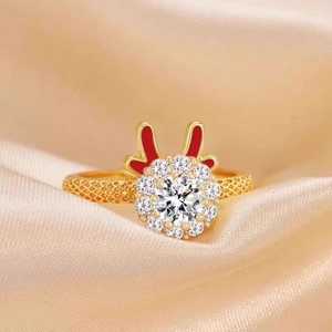 Detailed macro of golden reindeer ring with white zircons and red enamel accents