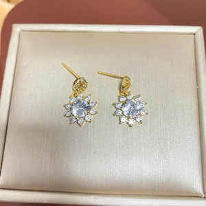 Macro detail of sunflower stud earrings with gold finish and brilliant-cut zircons