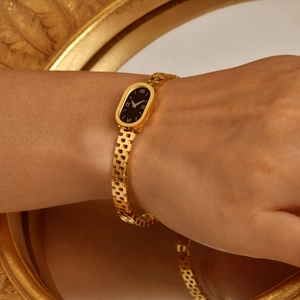 Bracelet montre vintage en acier doré avec cadran ovale noir et chiffres romains