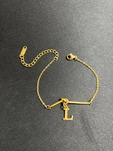 Detailansicht des goldenen Edelstahlarmbands mit einem großen L-Anhänger in Goldoptik