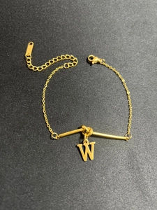 Detailansicht des goldenen Edelstahlarmbands mit W-Buchstabenanhänger und Punze
