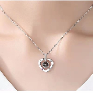 Silver heart projection necklace with Roman numerals worn on model as a luxury gift