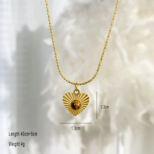 Macro detail of heart pendant with round tiger eye stone and golden sunburst edges