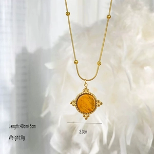 Macro detail of golden vintage necklace with tiger eye stone and 2.3cm round pendant