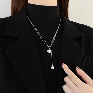 Elegant silver heart and star tassel necklace with Y-shaped chain on black blazer