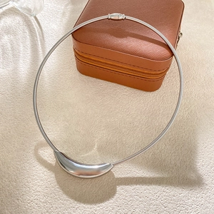 Dettaglio della collana choker in acciaio al titanio argento con ciondolo curvo