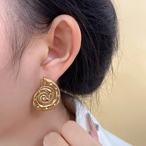 Detailed close-up of a vintage conch shell earring with sparkling white rhinestones