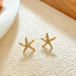 Close-up of gold starfish stud earrings with sparkling pavé cubic zirconia inlay
