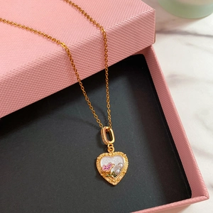 Dettaglio della collana a cuore vintage con fiore in smalto viola e inserti in perle