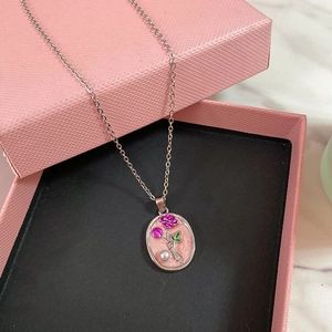 Dettaglio della collana in smalto rosa con rilievo a rosa su portagioie con marmo