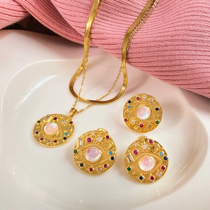 Detail of gold necklace set with pink main stone and colorful zircon evil eye design