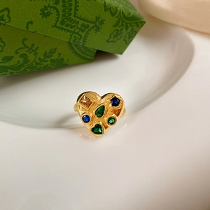 Macro shot of heart-shaped gold ring with multi-colored gemstone mosaic and vintage setting