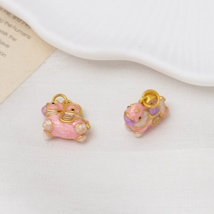 Detail of 3D rocking horse pendants in pink enamel and gold finish for DIY jewelry making