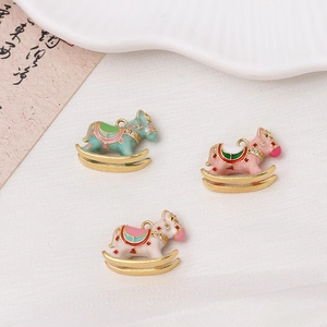 Detailed view of enamel rocking horse pendants in pastel colors with gold plating