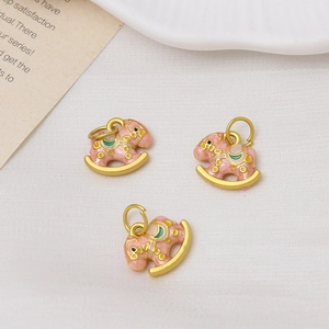 Detailed view of pink enamel rocking horse charms with golden plating for DIY jewelry making