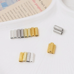 Detail of knurled metal tube beads in gold and silver for jewelry making