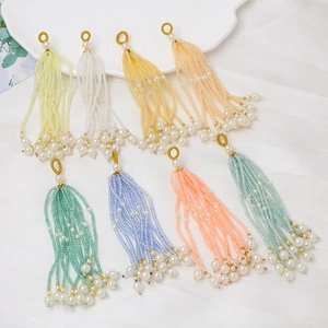Vista macro de borlas de cuentas de colores con anillos dorados y perlas para joyería DIY