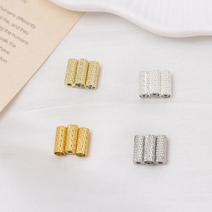 Detailed view of gold and silver magnetic tube spacers with knurled texture for jewelry