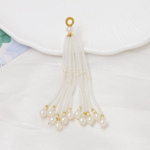 Primer plano de una elegante borla de perlas con detalles dorados para joyería artesanal