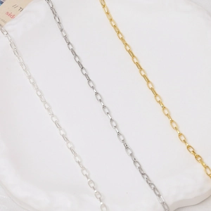 Dettaglio macro di catene a maglie graffetta oro e argento per creazione gioielli fai-da-te