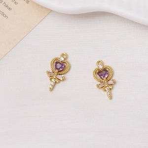 Detail of gold magic wand pendants with purple heart crystal and sparkling zircons