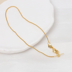 Detail einer verstellbaren goldenen Box-Kette mit Schiebeperle und Nadelende für Schmuck