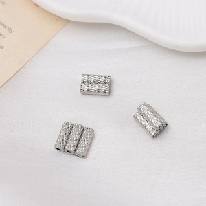 Macro view of silver knurled textured cylindrical spacers for DIY jewelry making