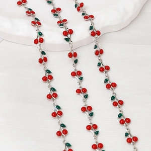 Detailed view of red cherry enamel charms on silver metal chains for DIY jewelry making