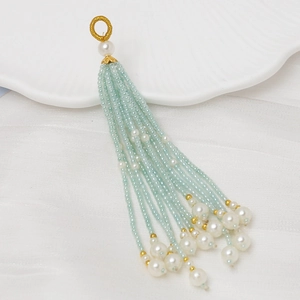 Detalle de borlas de cuentas azul claro con perlas blancas y acentos dorados finos