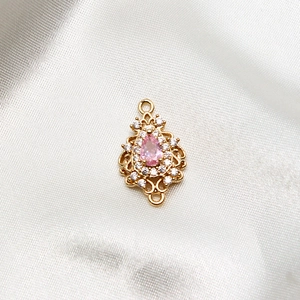 Detailed view of a vintage pink pear-shaped zircon pendant with gold plated finish
