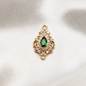 Detailed view of a green teardrop stone pendant with gold plating and white zircons
