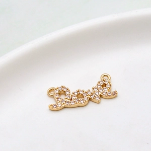 Makroaufnahme von Love-Anhänger in Gold mit weißen Zirkonia-Steinen für DIY-Schmuckherstellung