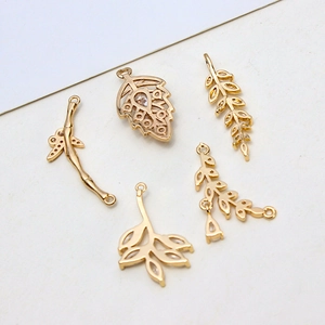 Detailed view of gold plated leaf and branch pendants with cubic zirconia for DIY jewelry