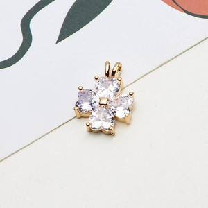 Macro detail of gold plated four-leaf clover pendant with heart-shaped white zircons