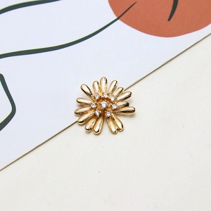 Macro detail of gold flower charm with micro-paved zircons and radiant texture