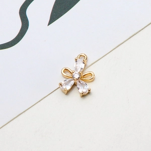 Macro shot of gold-plated copper flower pendant with white cubic zirconia and hanging loop