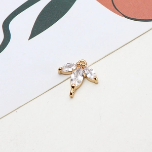 Detailed macro of gold clover pendant with marquise-cut zircons and double hanging rings