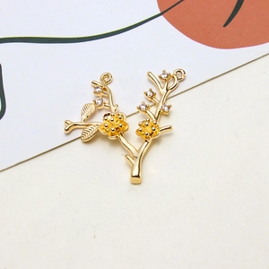 Close-up of golden flower branch jewelry pendant with zircon inlays and dual hanging loops