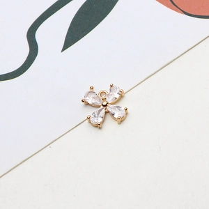 Close-up of a gold four-leaf flower pendant with zircon stones for DIY jewelry making