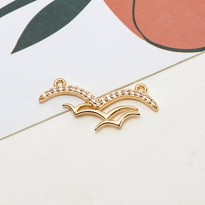 Detailed view of a gold-plated seagull pendant with sparkling zircon inlays for DIY jewelry