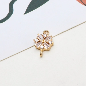 Macro shot of gold four-leaf clover pendant with clear zircons for DIY jewelry making