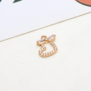Detail of gold-plated hollow heart pendant with micro-set zircons and a bow knot