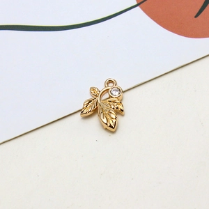 Detail of gold-plated leaf pendant with white zircon for DIY jewelry making