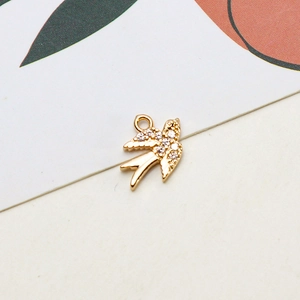 Macro view of a gold swallow pendant with white zircons for DIY jewelry making