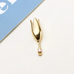 Macro shot of gold tulip pendant with white zircon for DIY jewelry and hair accessories