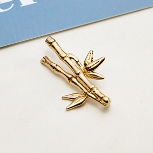 Macro detail of a polished gold bamboo branch pendant for DIY jewelry making
