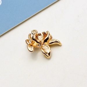 Macro view of a gold floral metal charm with multi-layered petals for jewelry making