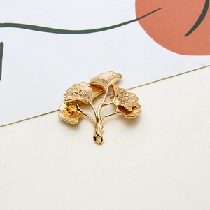 Makro-Detail des goldenen Ginkgoblatt-Anhängers für DIY-Ohrring-Schmuckherstellung