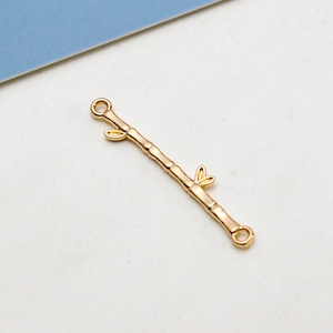 Macro detail of gold-plated bamboo joint charm connector for DIY jewelry crafting